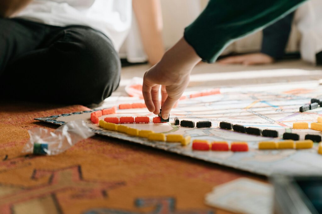 Pessoa movendo peças em um jogo de tabuleiro, simbolizando a troca de conhecimento, colaboração e construção coletiva de soluções — conceitos centrais no Stack Overflow.