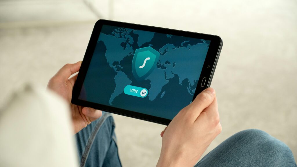 Pessoa segura um tablet exibindo uma interface de VPN ativa sobre um mapa-múndi, representando proteção digital e segurança adaptativa em tempo real.