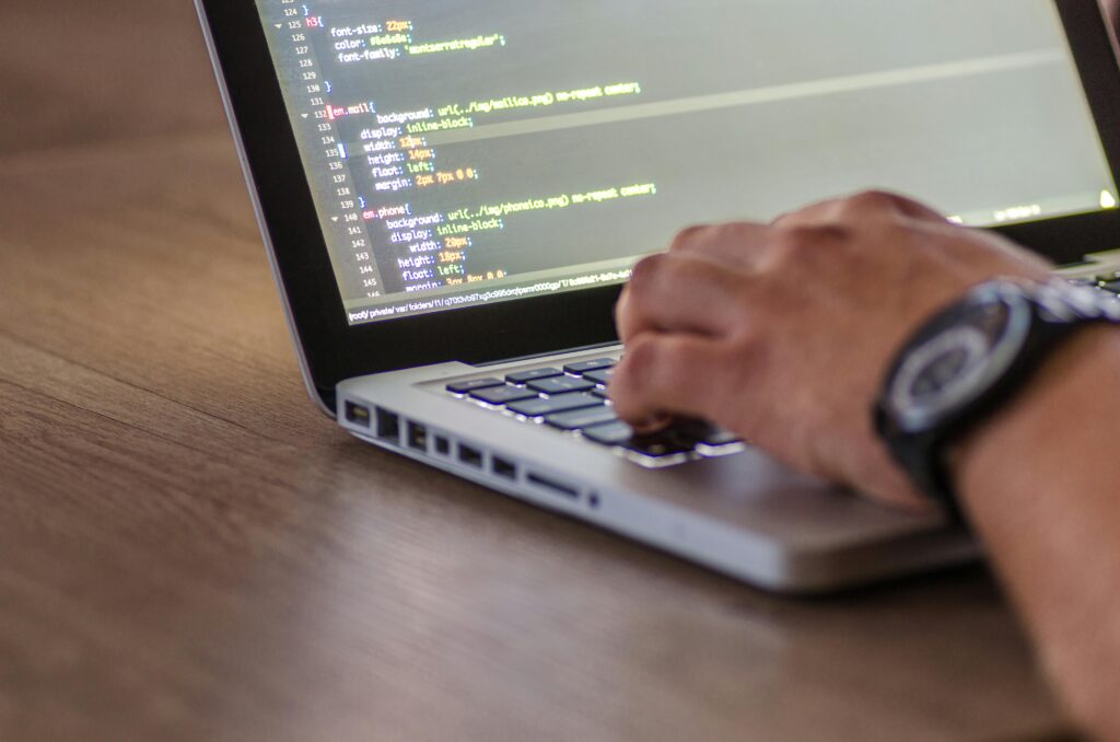 Pessoa programando em laptop, conceito de automação e integração contínua em DevOps.