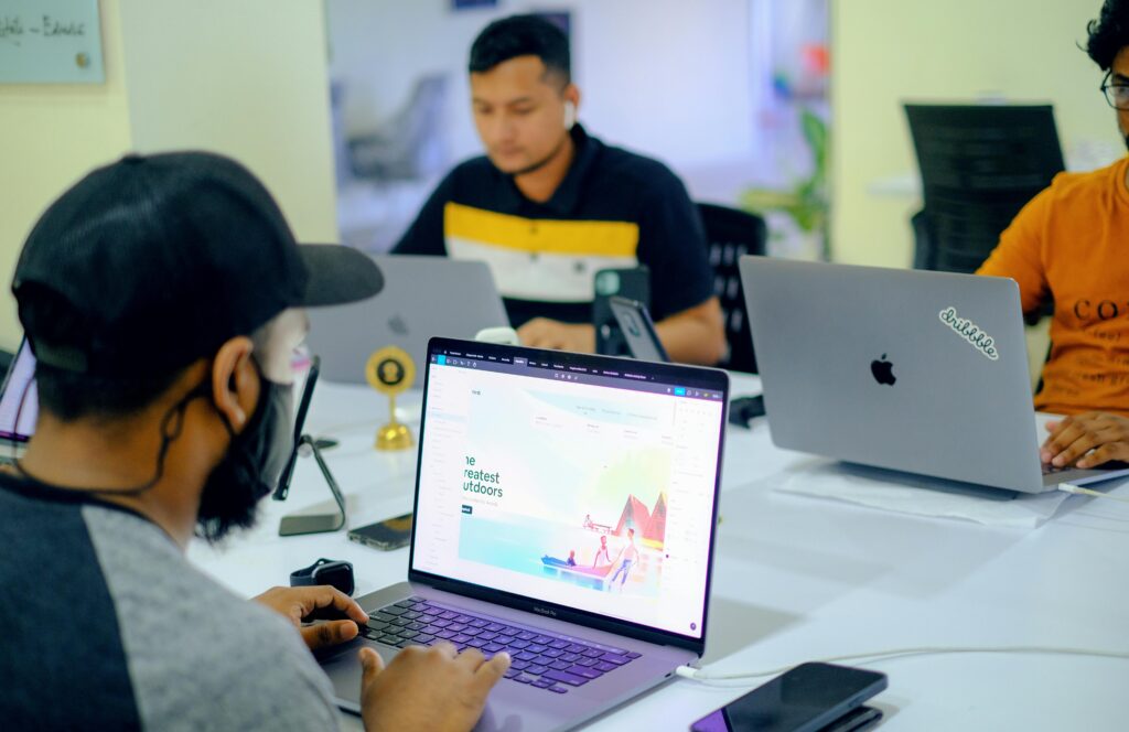 Equipe de tecnologia trabalhando em laptops em um coworking, representando o desenvolvimento de MVPs para validação rápida de produtos digitais no mercado.