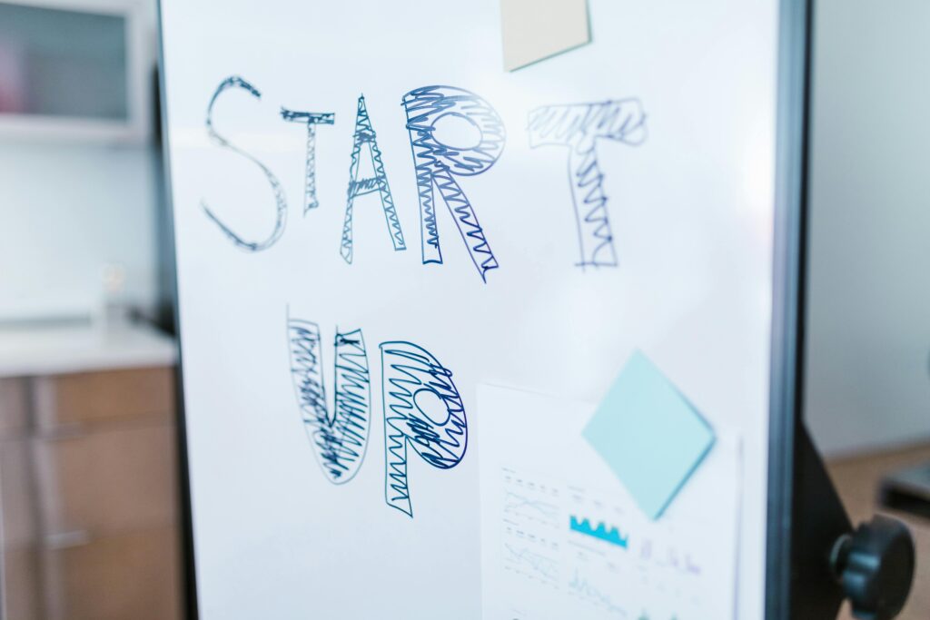 Quadro branco com a palavra "STARTUP" desenhada à mão, representando a metodologia ágil focada em adaptação rápida e entrega de valor contínuo no desenvolvimento de produtos.