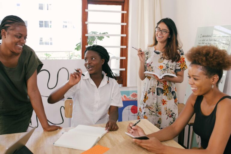 Equipe reunida em ambiente descontraído, planejando atividades com cadernos e tablets, representando a agilidade, colaboração e foco na entrega de valor em ciclos curtos de uma sprinter.
