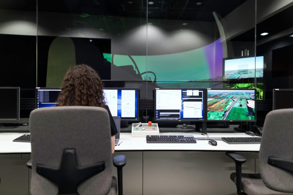 Profissional operando múltiplos monitores com sistemas e dados geográficos em ambiente tecnológico, representando o modelo Everything as a Service (XaaS) aplicado a operações remotas e inteligentes.