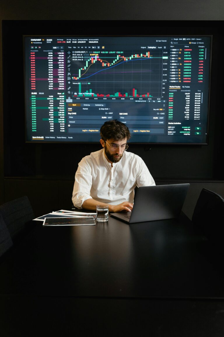 Profissional analisa dados em tempo real com gráficos de mercado em tela, representando o uso de edge computing para processar informações com baixa latência.