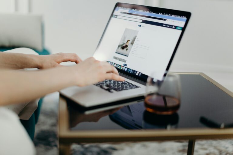 Pessoa realizando upload de conteúdo digital em um notebook, com interface de plataforma aberta na tela e ambiente propício ao trabalho remoto.