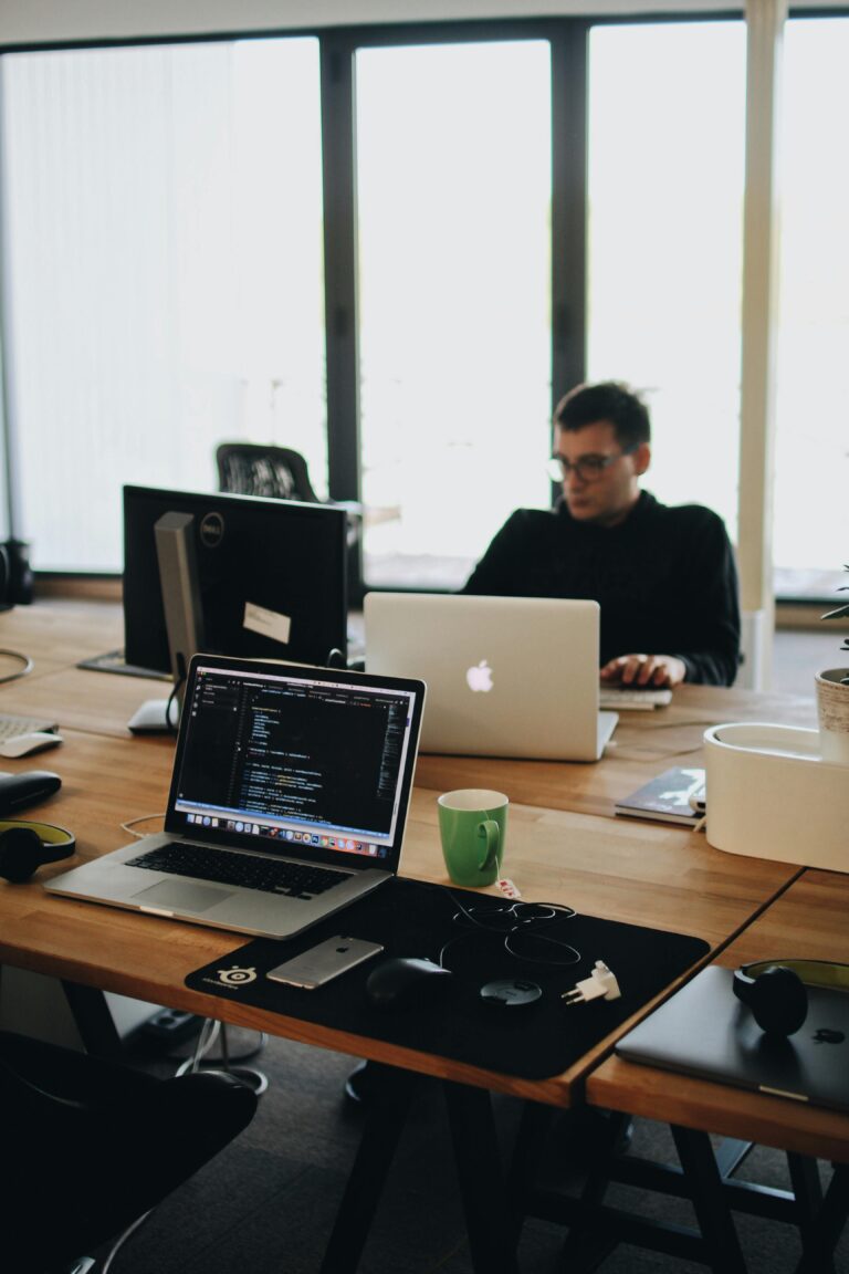 Pessoa programando em um laptop com código aberto na tela, representando o desenvolvimento e a gestão de domínios na era digital.