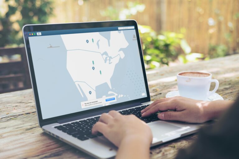 Pessoa usando laptop ao ar livre com interface de conexão VPN aberta, exibindo mapa de servidores e aviso de desconexão.