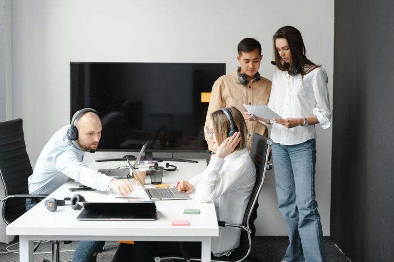Quatro profissionais de tecnologia reunidos em um ambiente corporativo, usando headsets e laptops, colaborando sobre soluções de segurança digital com foco em SSL (Secure Sockets Layer).