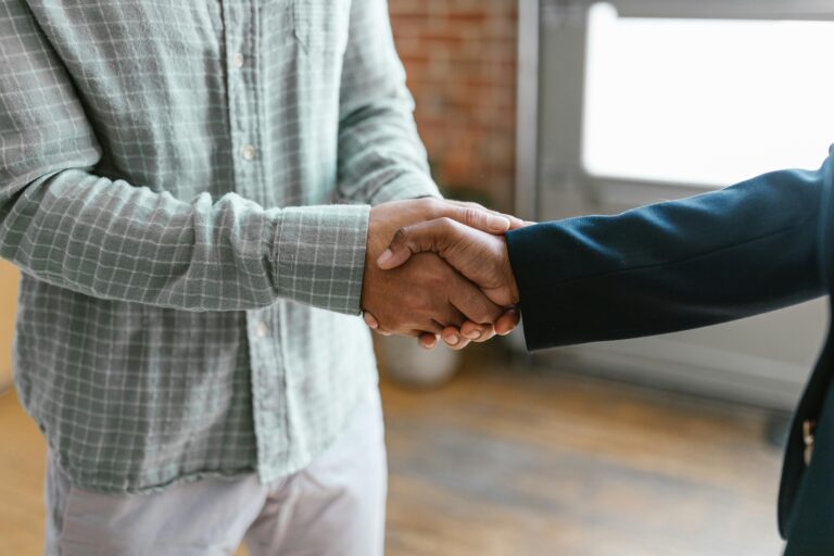 Aperto de mãos entre duas pessoas simbolizando confiança, acordo e responsabilidade, conceitos fundamentais da ética digital em ambientes corporativos e online.
