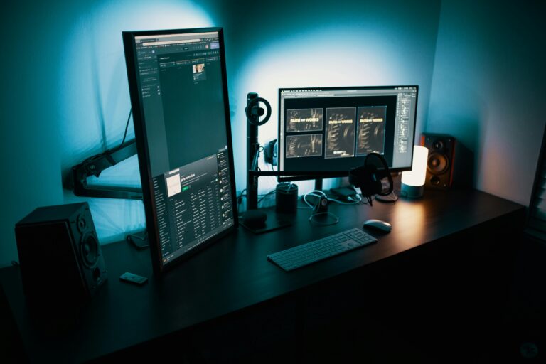 Setup moderno com dois monitores exibindo interfaces de dados e IA, representando o uso de MCP e RAG para governança corporativa digital.