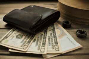 Carteira de couro sobre cédulas de dólar, simbolizando o potencial econômico dos ativos tokenizados com a duplicata escritural lançada pelo Banco Central.