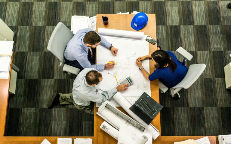 Equipe analisando documentos financeiros em reunião, representando a importância de um backoffice financeiro personalizado para reduzir custos.