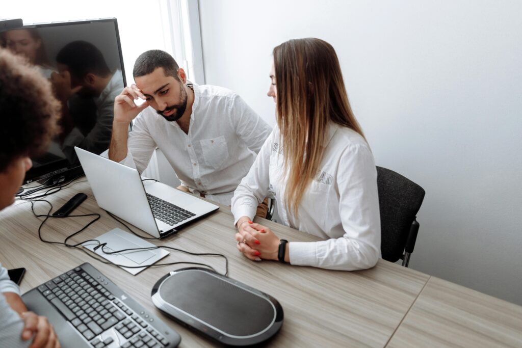 Profissionais reunidos em frente a notebooks discutem soluções para migração de sistemas para SAP na nuvem.