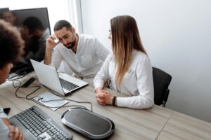 Profissionais reunidos em frente a notebooks discutem soluções para migração de sistemas para SAP na nuvem.