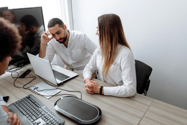 Profissionais reunidos em frente a notebooks discutem soluções para migração de sistemas para SAP na nuvem.