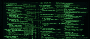 Uma tela de computador escura exibe várias linhas de código de programação em verde brilhante, evocando a estética de cibersegurança e computação de matriz.