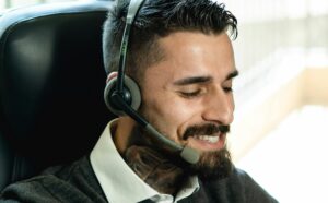 Profissional em escritório utilizando notebook e headset para estruturar prompts estratégicos de inteligência artificial.