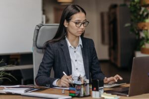 Gestora trabalhando concentrada em seu notebook para implementar a automação de processos e reduzir o tempo gasto com tarefas manuais repetitivas.